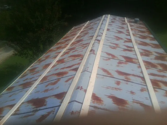 Rusted metal roof panels with new wood purlins before replacement — Storm Damage Roof Repair in Clyde by Roofing Brothers